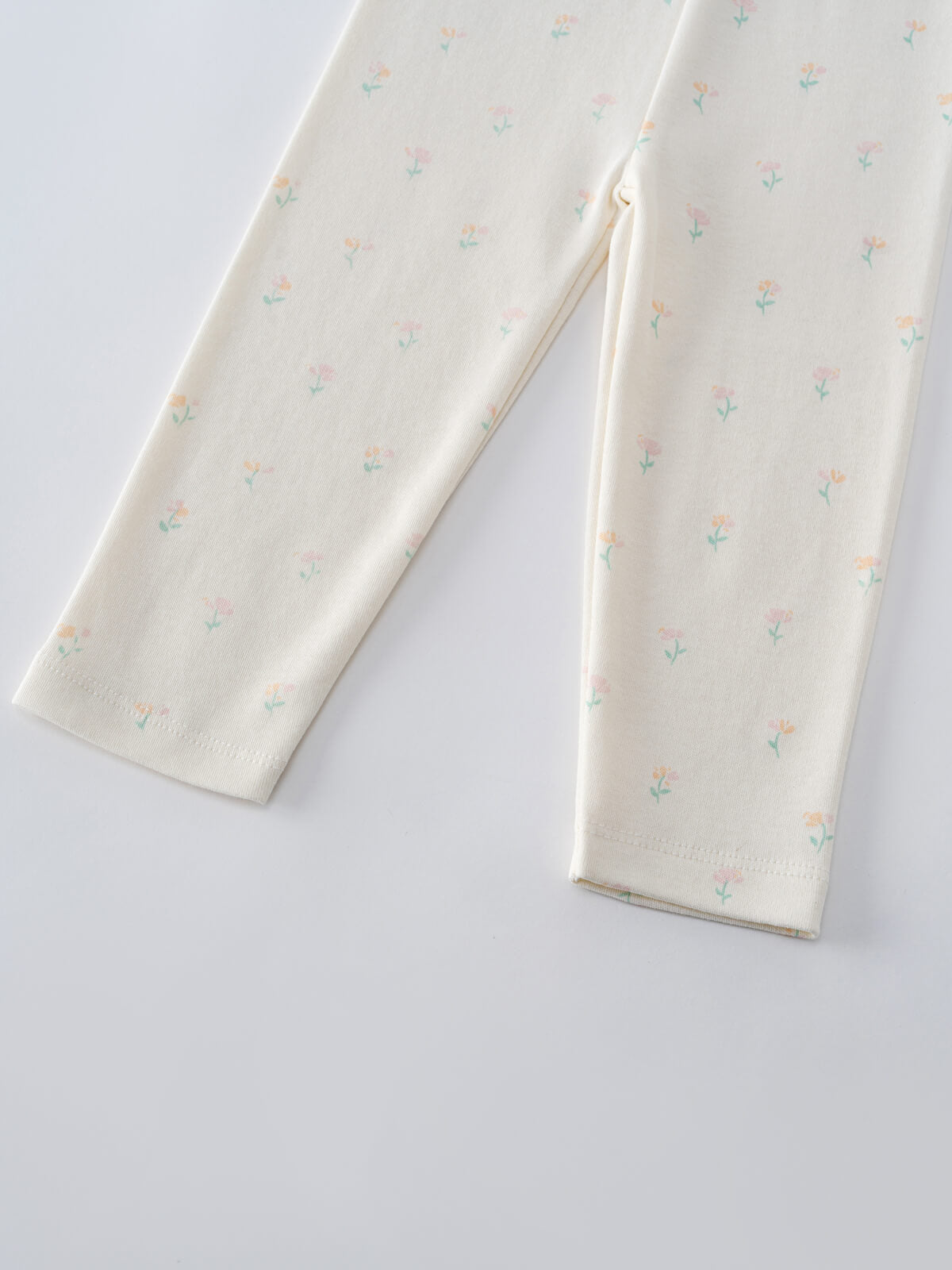 Close-up of cream-colored leggings with small floral print pattern Baby Printed Leggings - Spring Bloom Baby girl