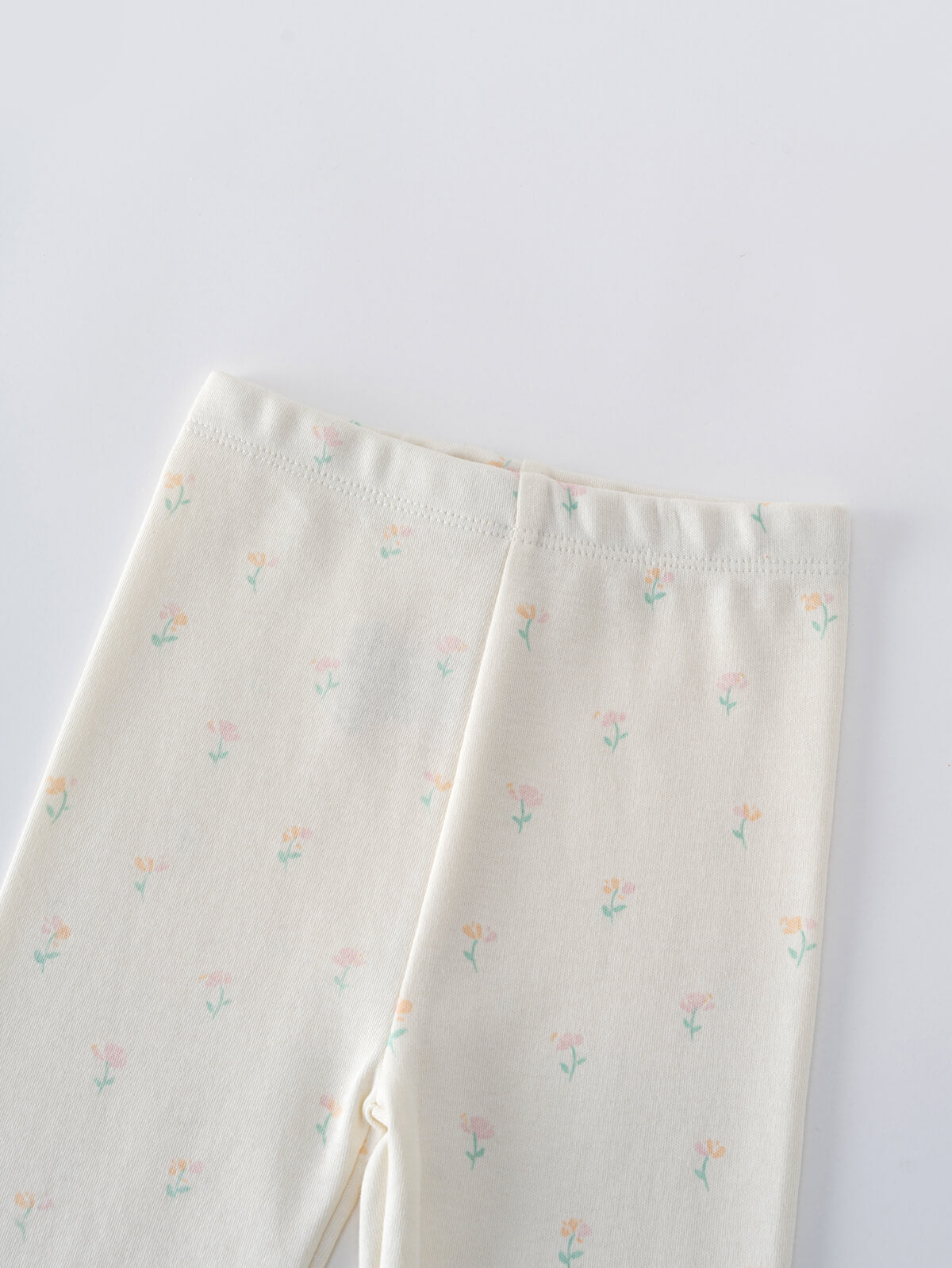 Close-up of cream-colored baby leggings with small pastel floral print Baby Printed Leggings- Spring Bloom Baby girl