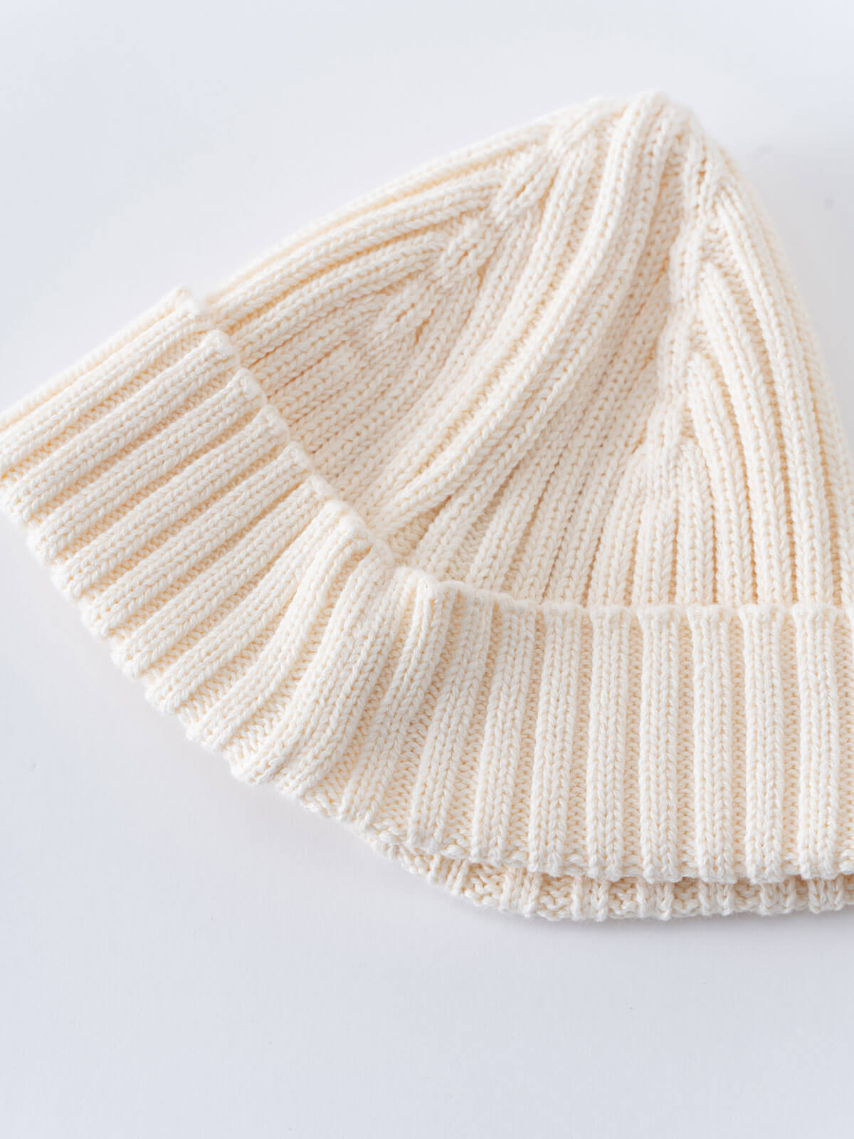 Beige knitted beanie on a light gray background Baby Ribbed Beanie - Ecru Baby boy