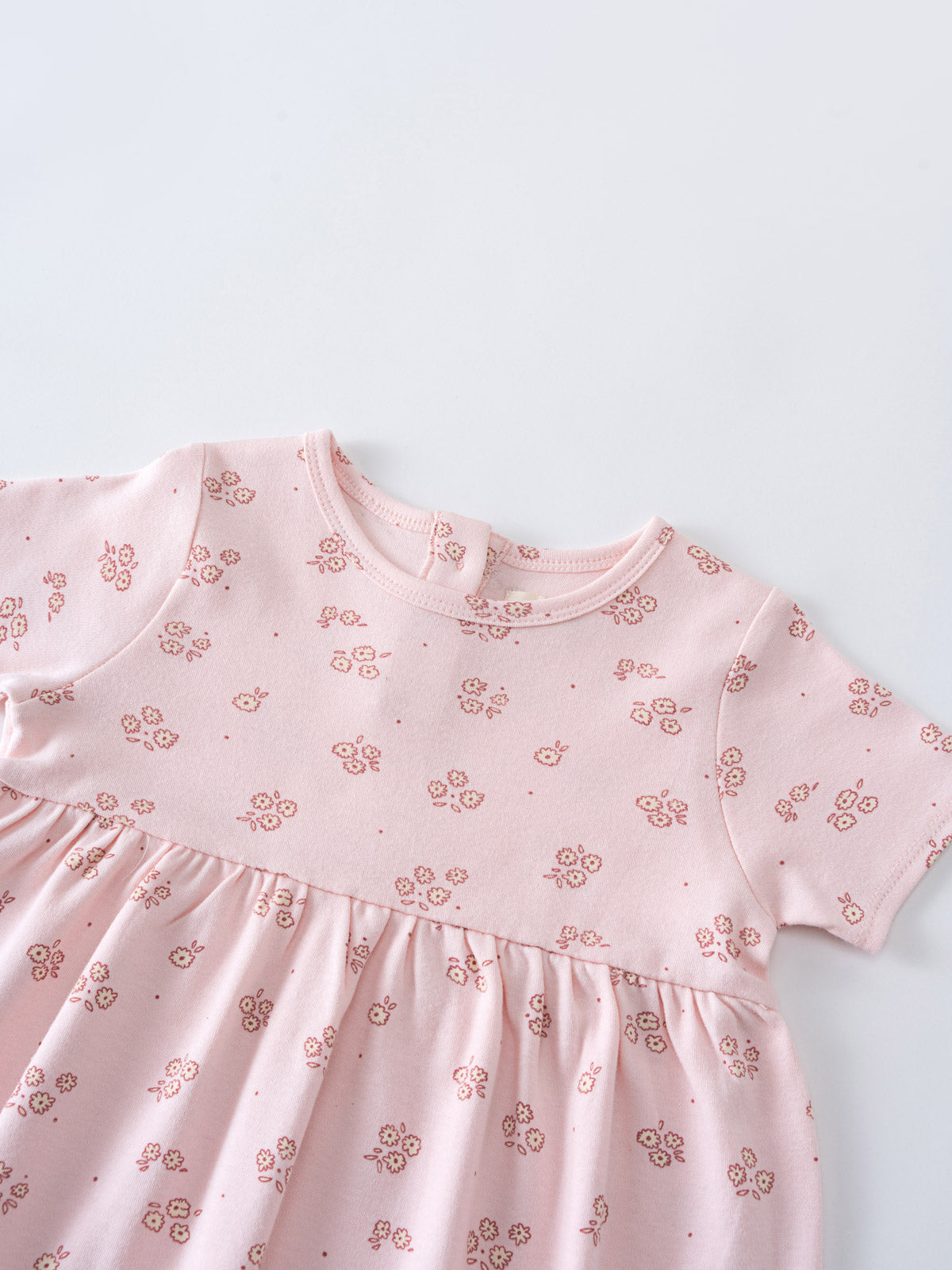 Close-up of a pink floral patterned dress with gathered waist detail Baby Short Sleeve Jersey Dress - Daisy Chain Baby girl
