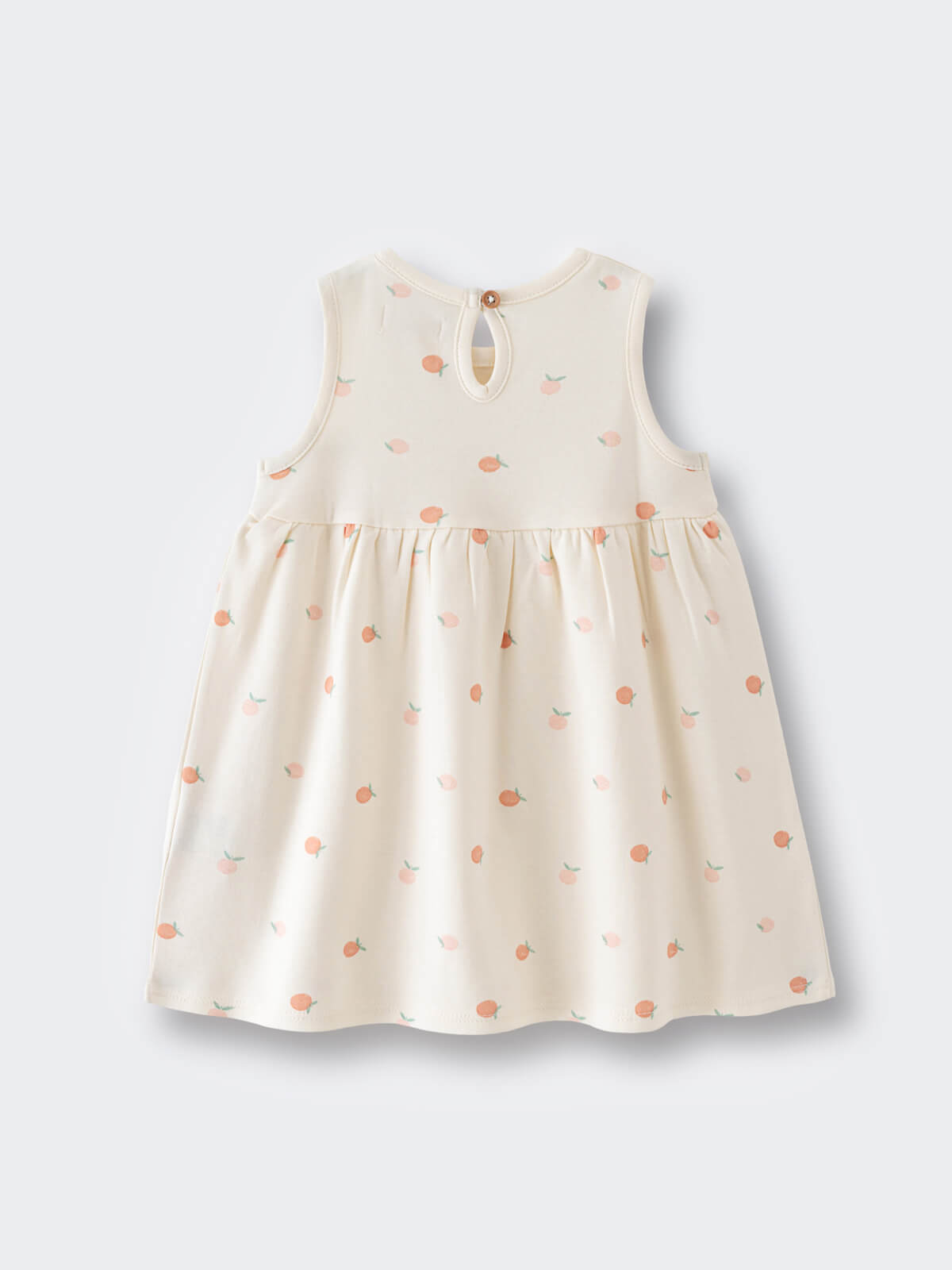 Cream-colored sleeveless baby dress with peach apple print pattern laid flat Baby Sleeveless Jersey Dress - Apples Baby girl