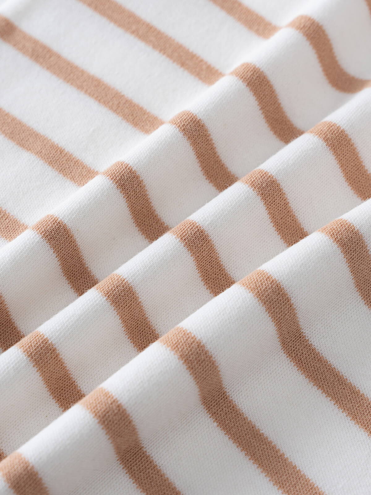 Close-up of white fabric with tan horizontal stripes showing texture and folds baby Sleeveless Tee - Sand Stripe Baby boy