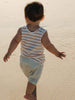 toddler boy walking on the sand wearing a striped sleeveless cotton tee