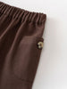 Close-up of brown twill pants showing elastic waistband and button pocket detail Baby Twill Pants - Spruce Baby boy