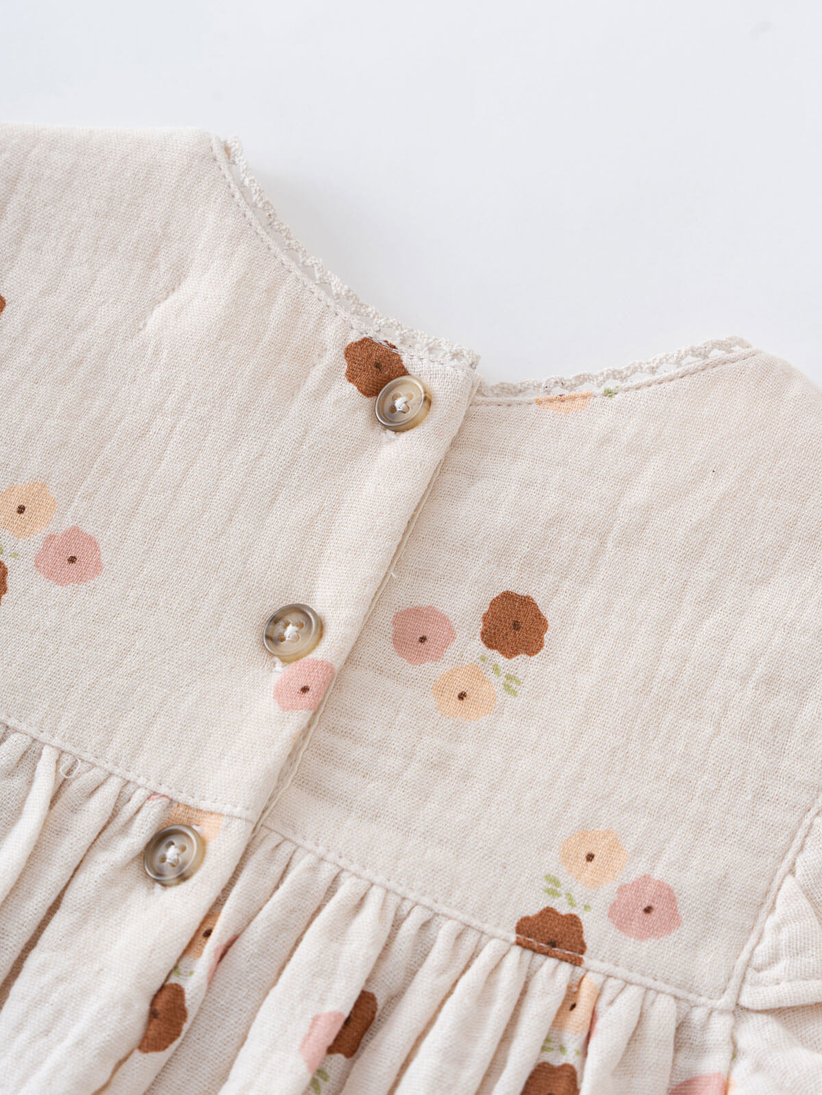 Close-up of a baby dress with floral patterns and buttons on a light background Baby Woven Dress - Autumn Bouquet Ecru Baby girl