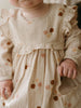 Baby wearing a floral dress with a soft focus background Baby Woven Dress - Autumn Bouquet Ecru Baby girl