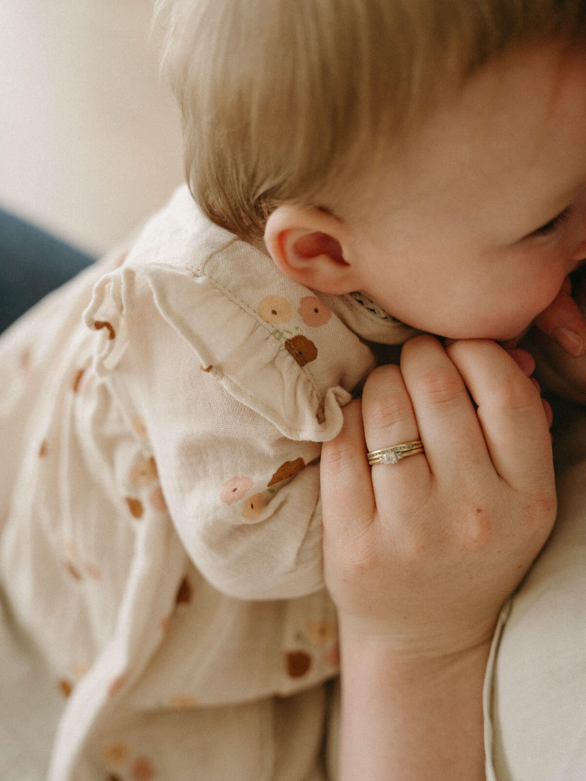 Baby being held close to a person wearing a ring, with a soft focus background Baby Woven Dress - Autumn Bouquet Ecru Baby girl