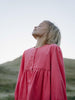 Girl wearing a pink shirt with a blurred natural background Button Through Dress - Cloudberry Girls
