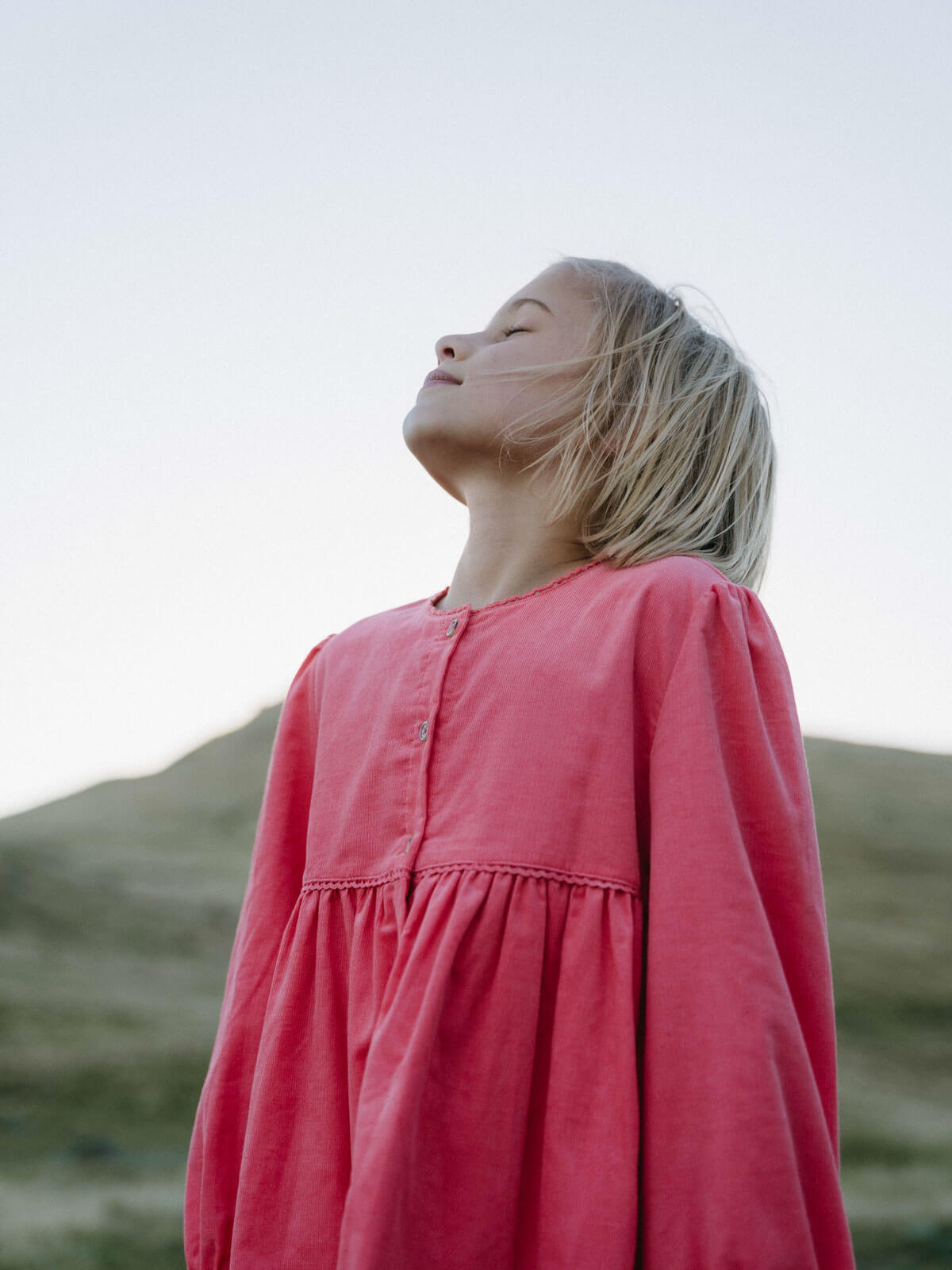 Girl wearing a pink shirt with a blurred natural background Button Through Dress - Cloudberry Girls