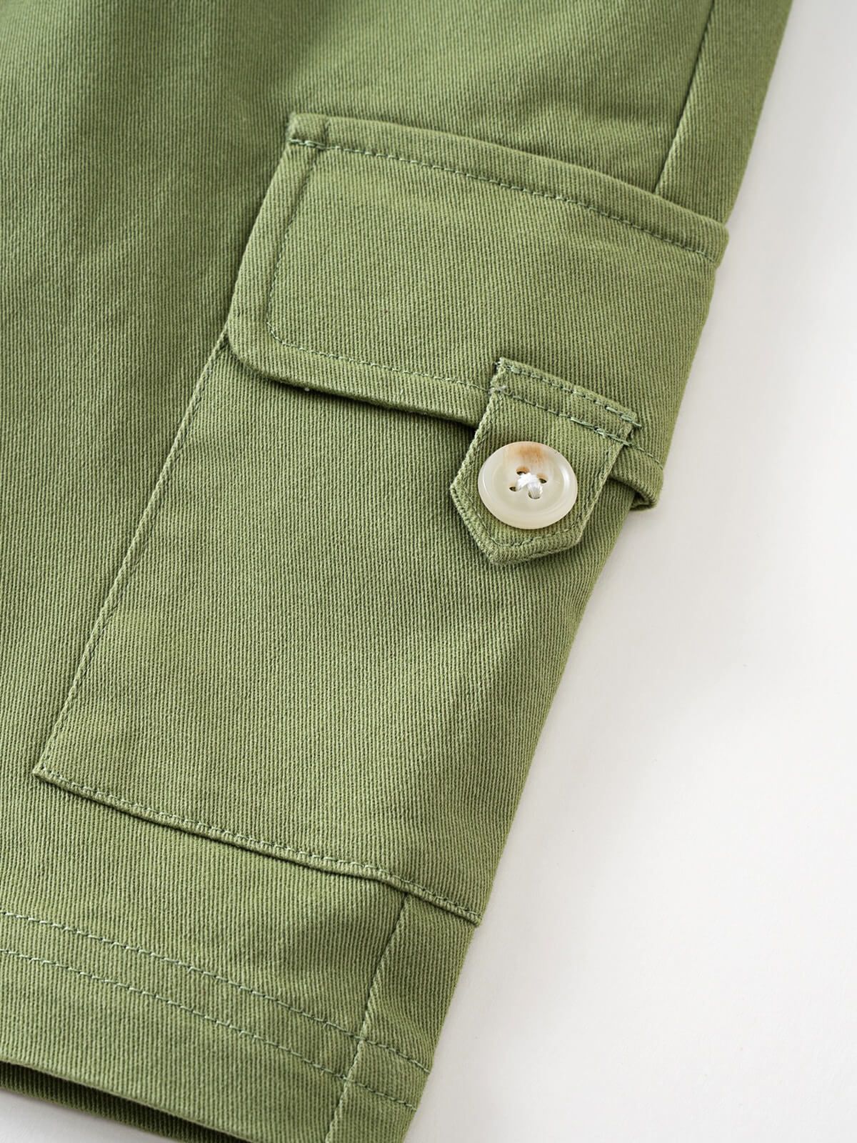 Close-up of olive green shorts showing pocket detail and cream button Cargo Shorts - Calla Green Boys