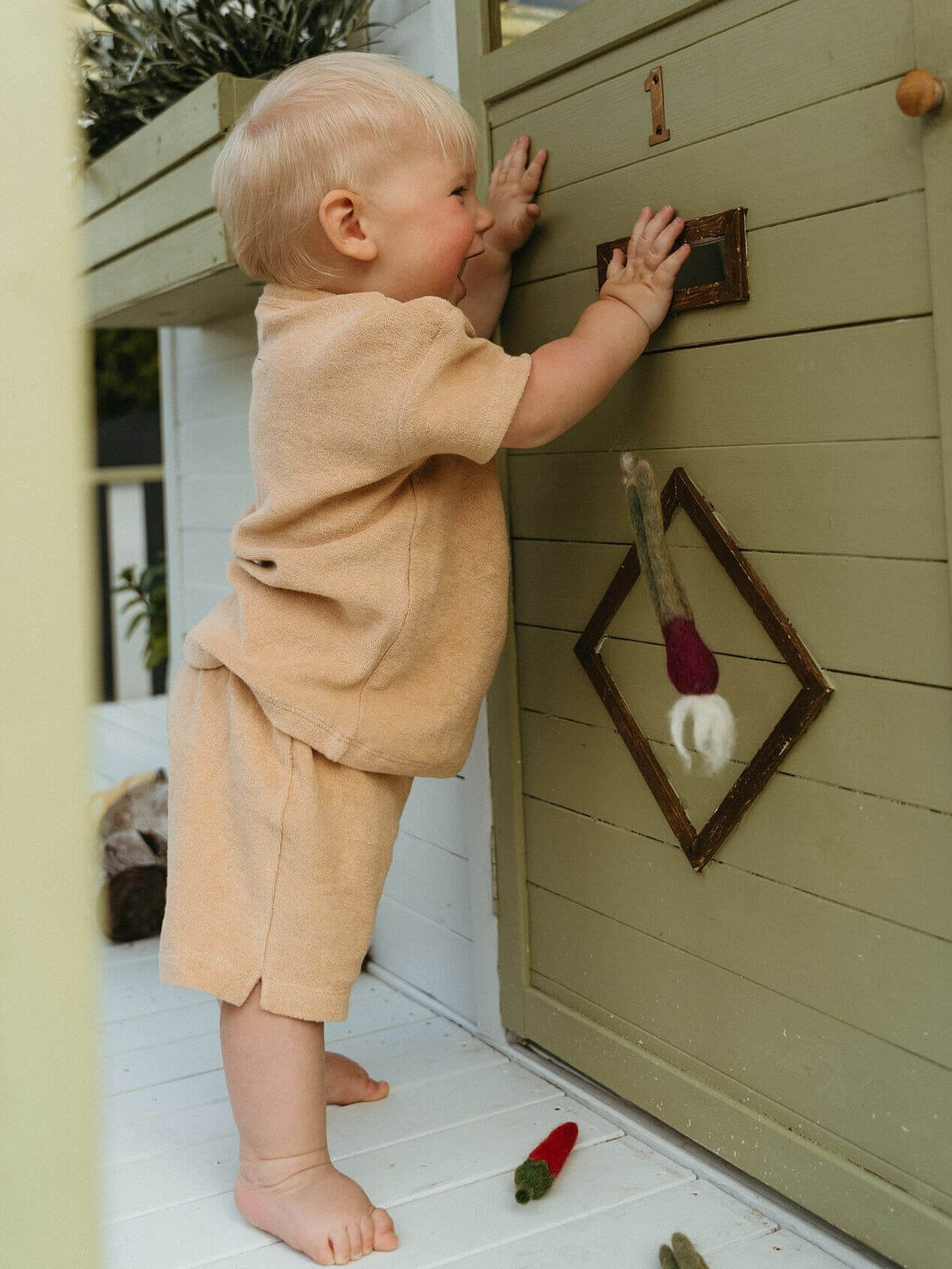 Child playing with a wooden playhouse door Carter Towelling Shorts - Sand Baby boy