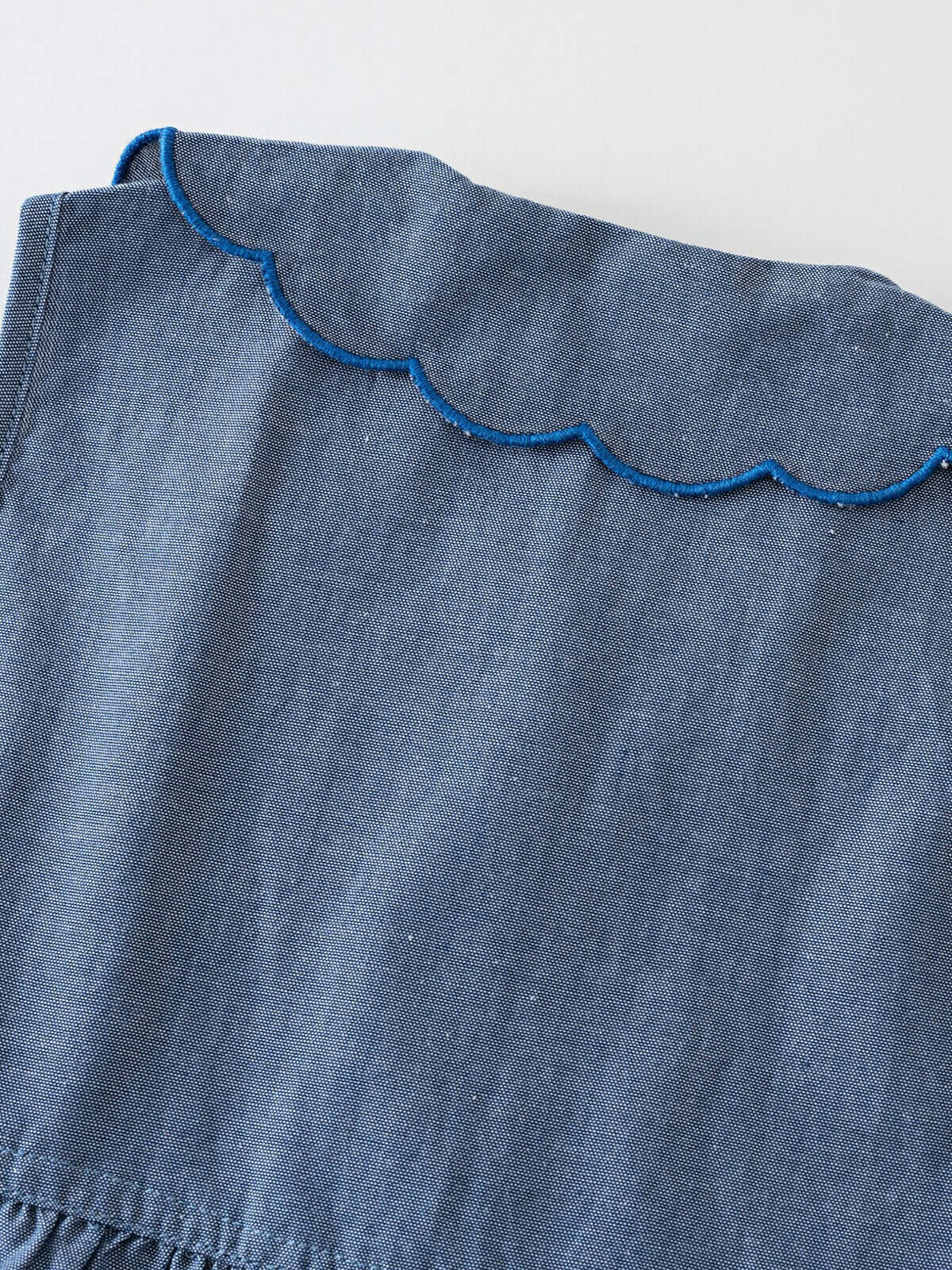Close-up of blue chambray fabric with scalloped blue trim detail chambray Dress - Blue Chambray Girls