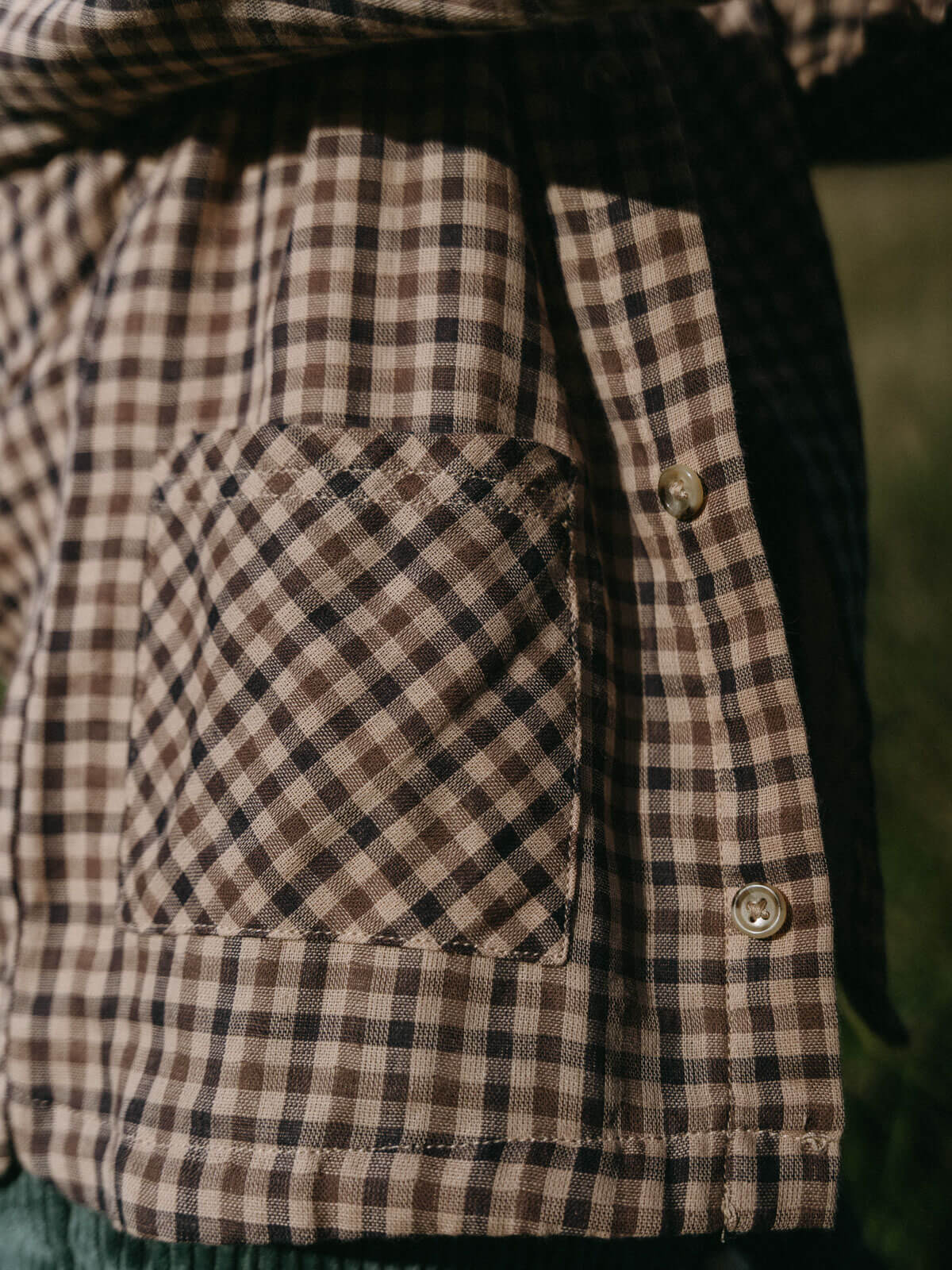 Close-up of a brown and black checkered jacket with a pocket. Check Shirt - Muslin Cotton Check Boys