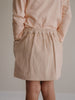 girl wearing a beige corduroy skirt and peach long-sleeve top against a neutral background Corduroy Skirt - Clay Girls