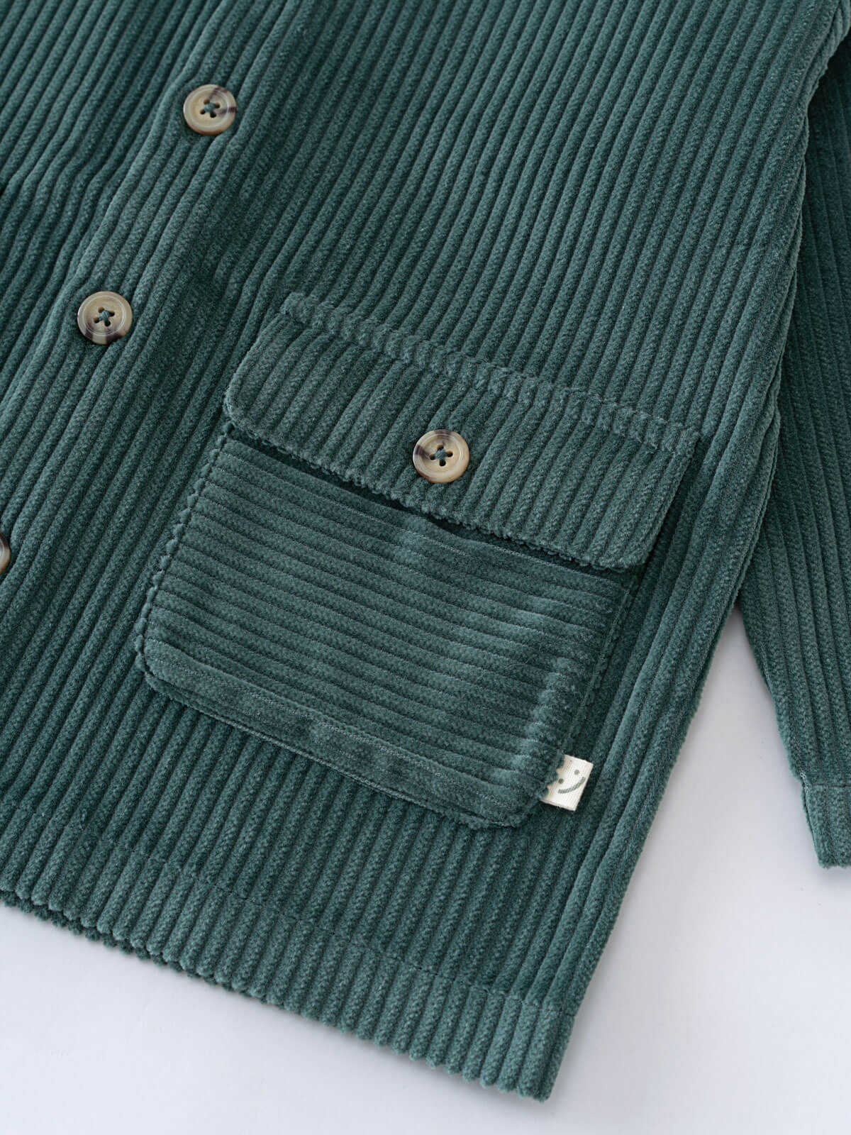 Close-up of teal corduroy jacket showing pockets and tan buttons Corduroy Jacket - Balsam Girls and Boys