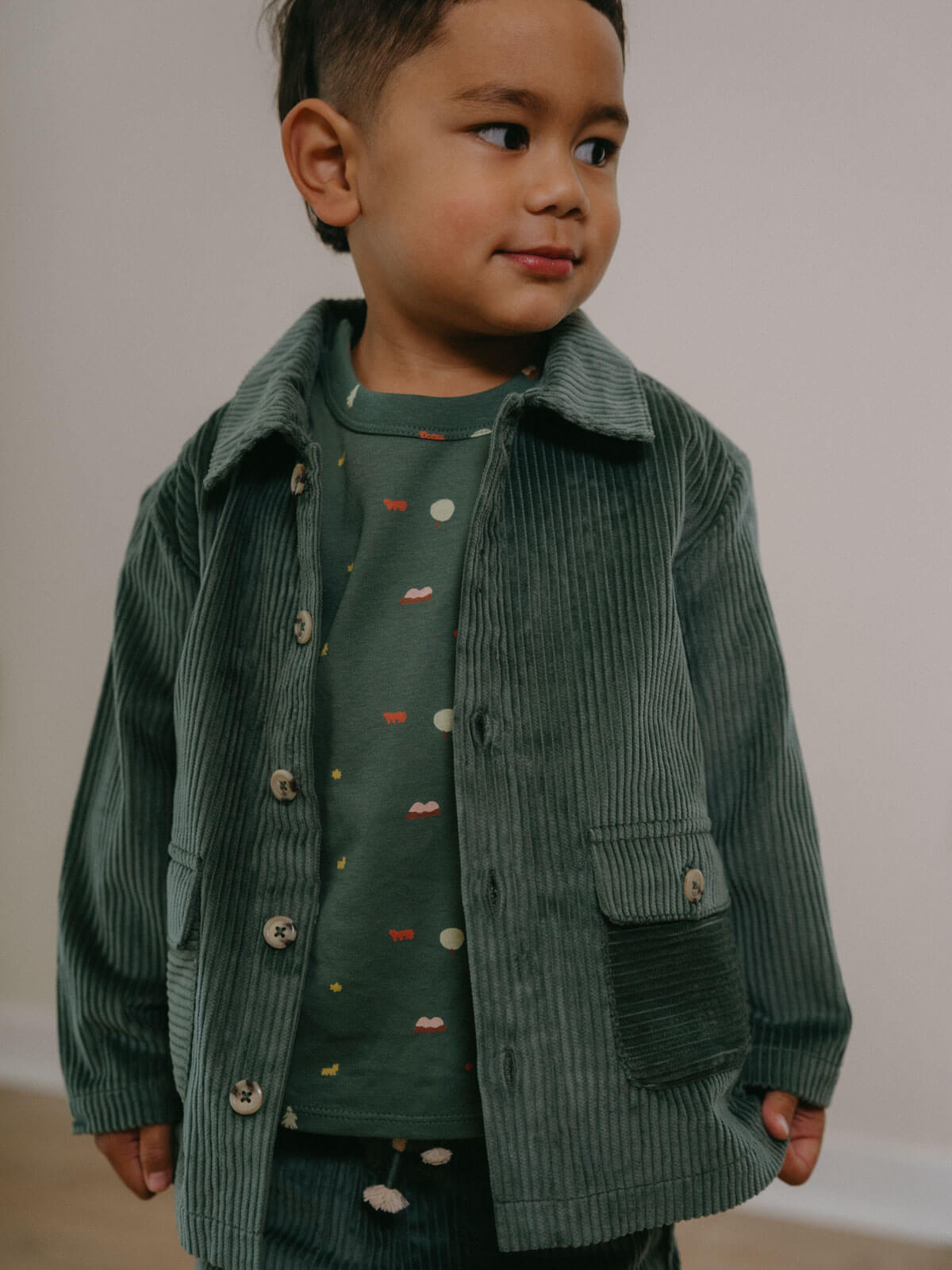 Child wearing a green corduroy jacket and shirt with a plain background Corduroy Jacket - Balsam Girls and Boys
