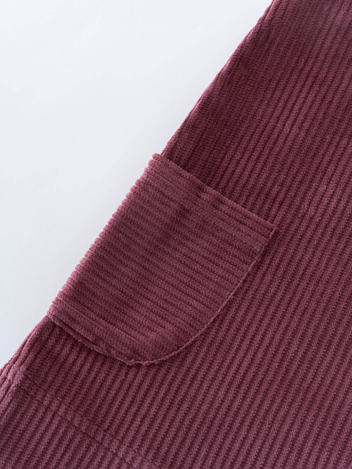 Close-up of a plum corduroy pinafore dress with a pocket on a white background Corduroy Pinafore Dress - Plum Jam Girls
