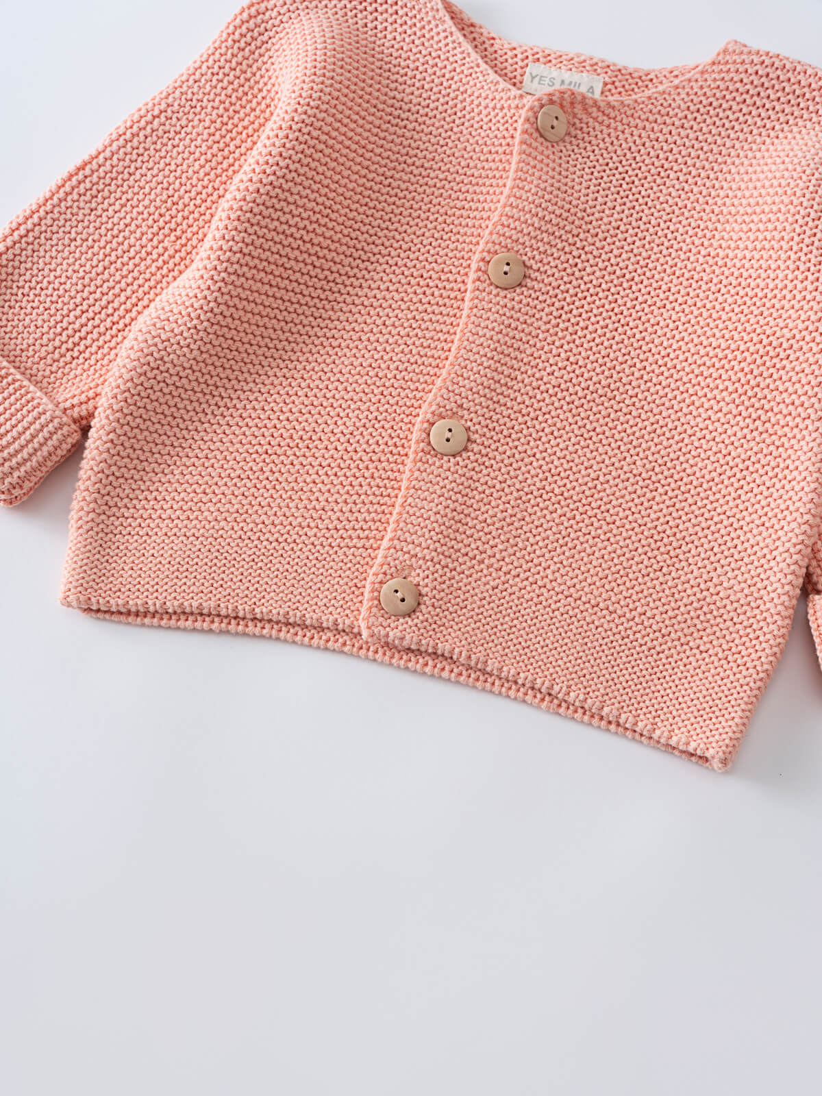 Close-up of a pink knitted cardigan with wooden buttons Cotton Cardigan - Toasted Peach Baby girl
