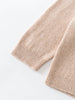 Close-up of a beige knitted sweater sleeve on a white background