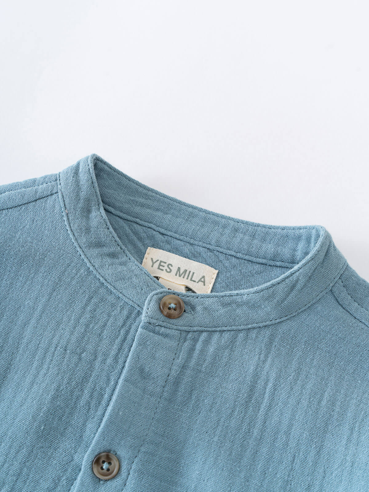 Close-up of a blue garment with a visible brand label on a white background Grandad Shirt - Lake Blue Boys