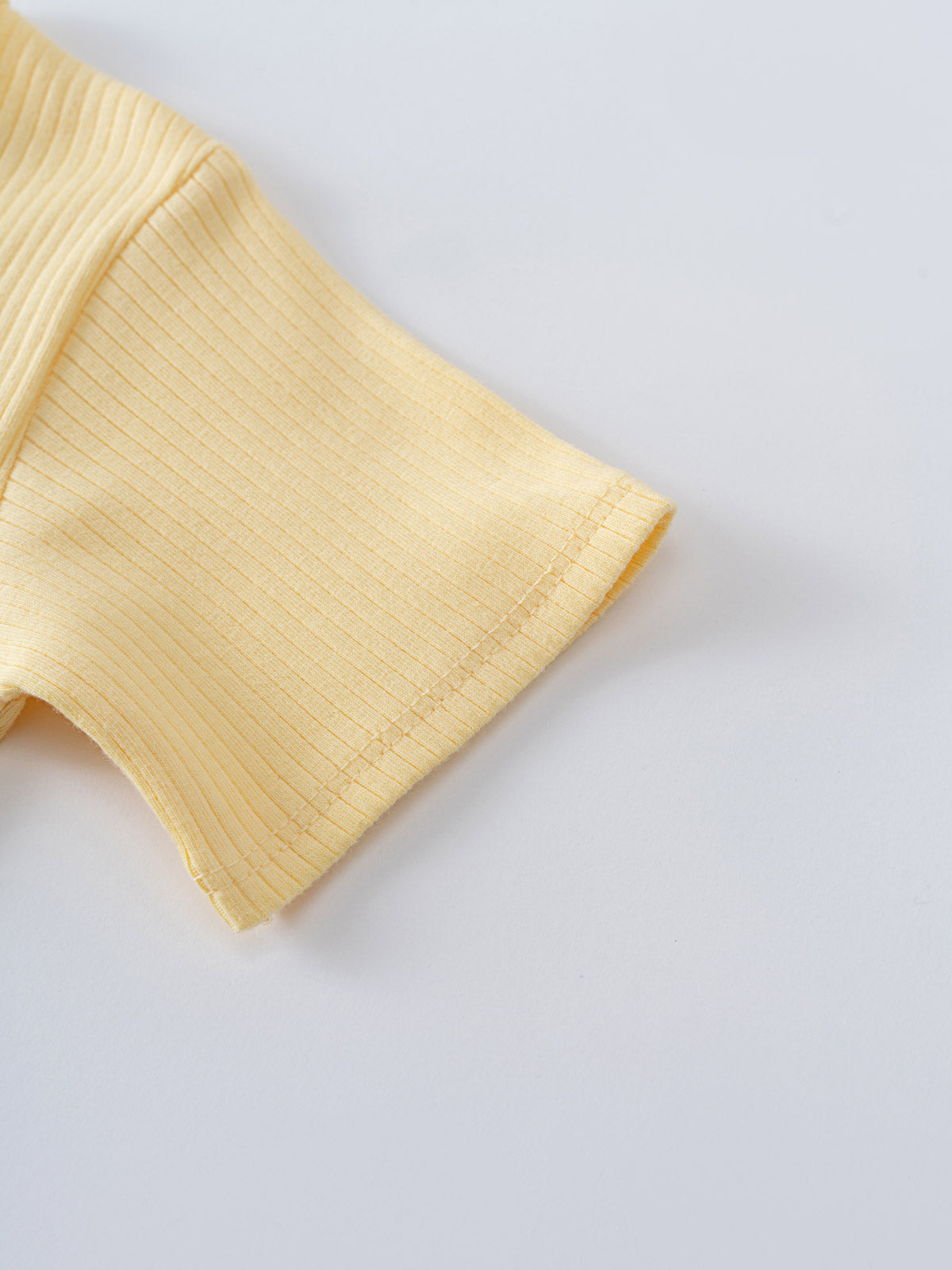 Close-up of a yellow ribbed knit fabric sleeve on white background Henley Short Sleeve Bodysuit- Sun Soaked Baby girl