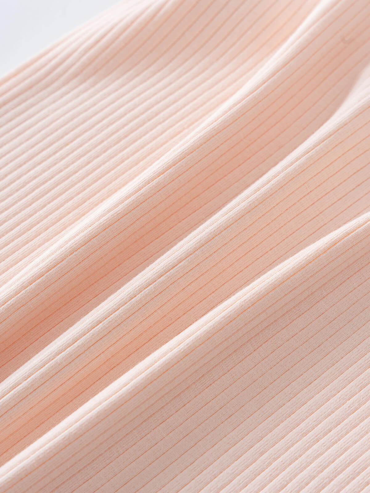 Close-up of ribbed fabric texture in soft peachy pink color Henley Short Sleeve Bodysuit - Shell Pink Baby girl