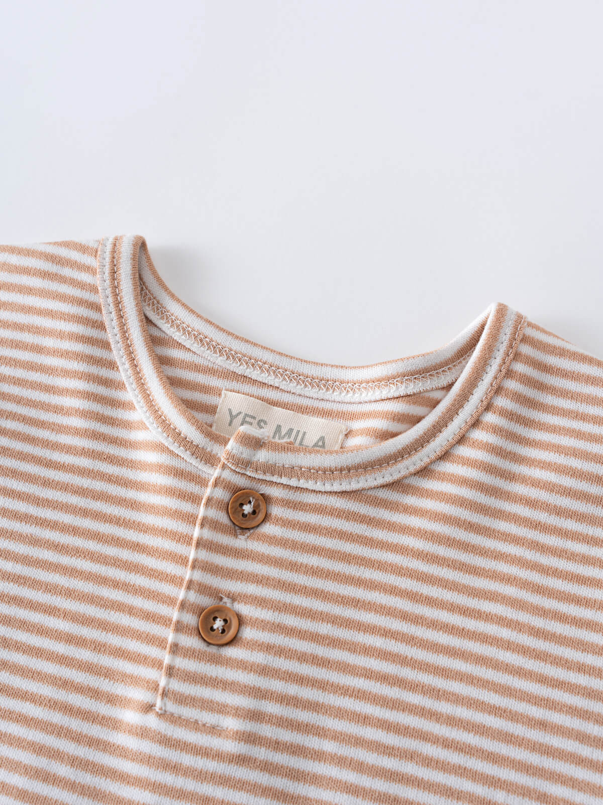 Close-up of a striped shirt with brown buttons and visible label Henley Tee - Sand Stripe Baby boy