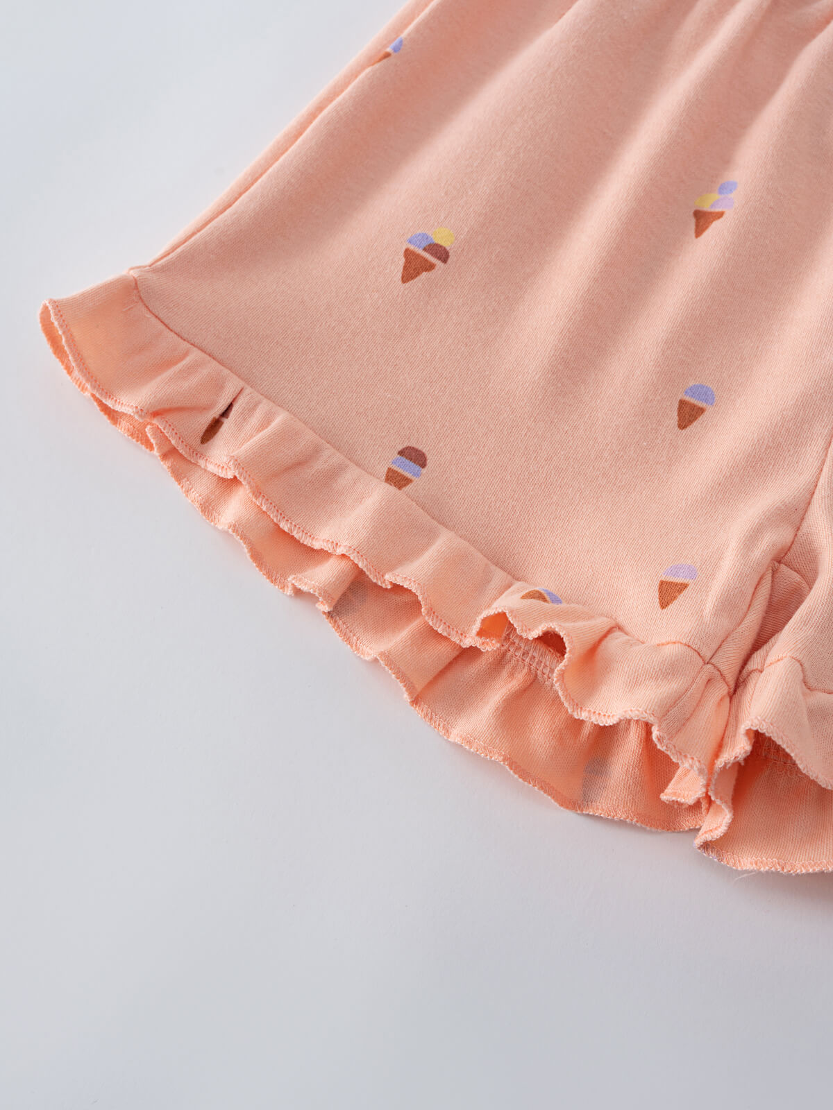 Close-up of peach fabric with ice cream print and ruffled hem detail Jersey Shorts - Ice Creams Girls