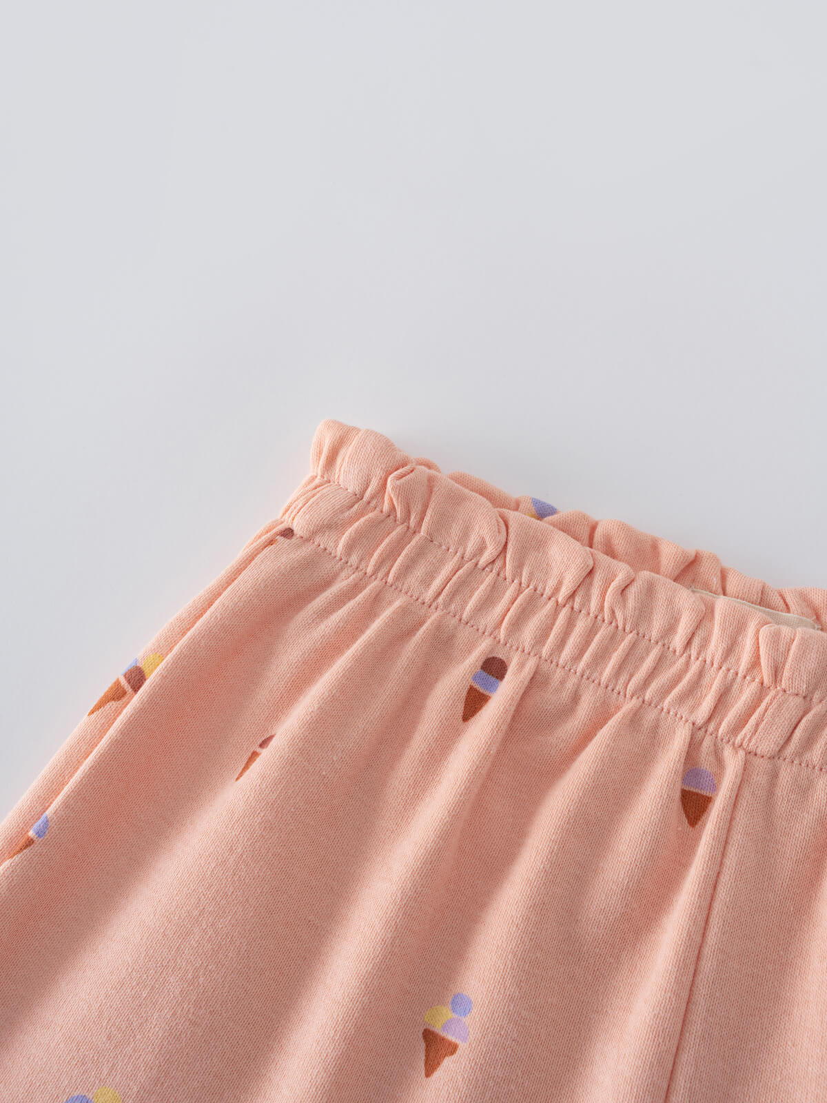 Close-up of peach-colored shorts with ice cream cone pattern and elastic waistband Jersey Shorts - Ice Creams Girls