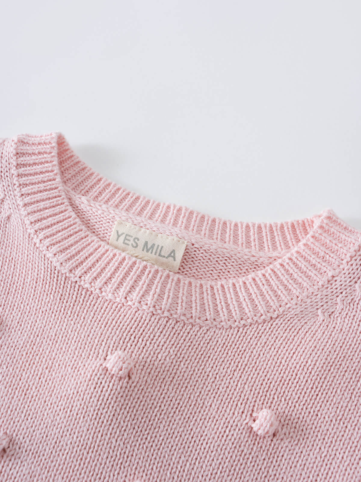 Close-up of a pink knitted sweater with visible brand label on neckline Knit Jumper - Candy Floss Girls