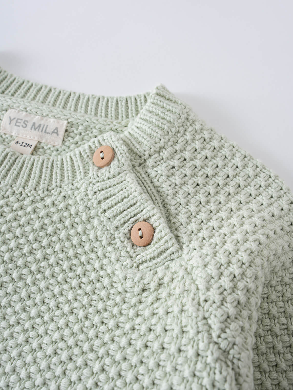 Close-up of a mint green knitted baby sweater with wooden buttons Knit Jumper - Mint Baby boy