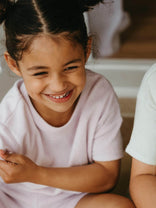Young girl smiling with a blurred person next to her