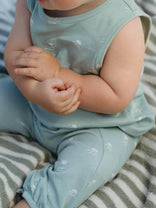 Baby in light blue outfit sitting on a striped surface
