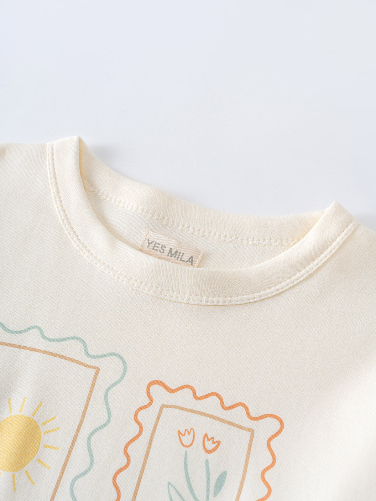 Close-up of cream-colored tee collar with illustrated frames containing sun and flowers Long Sleeve Tee - Sunny Club Day Girls