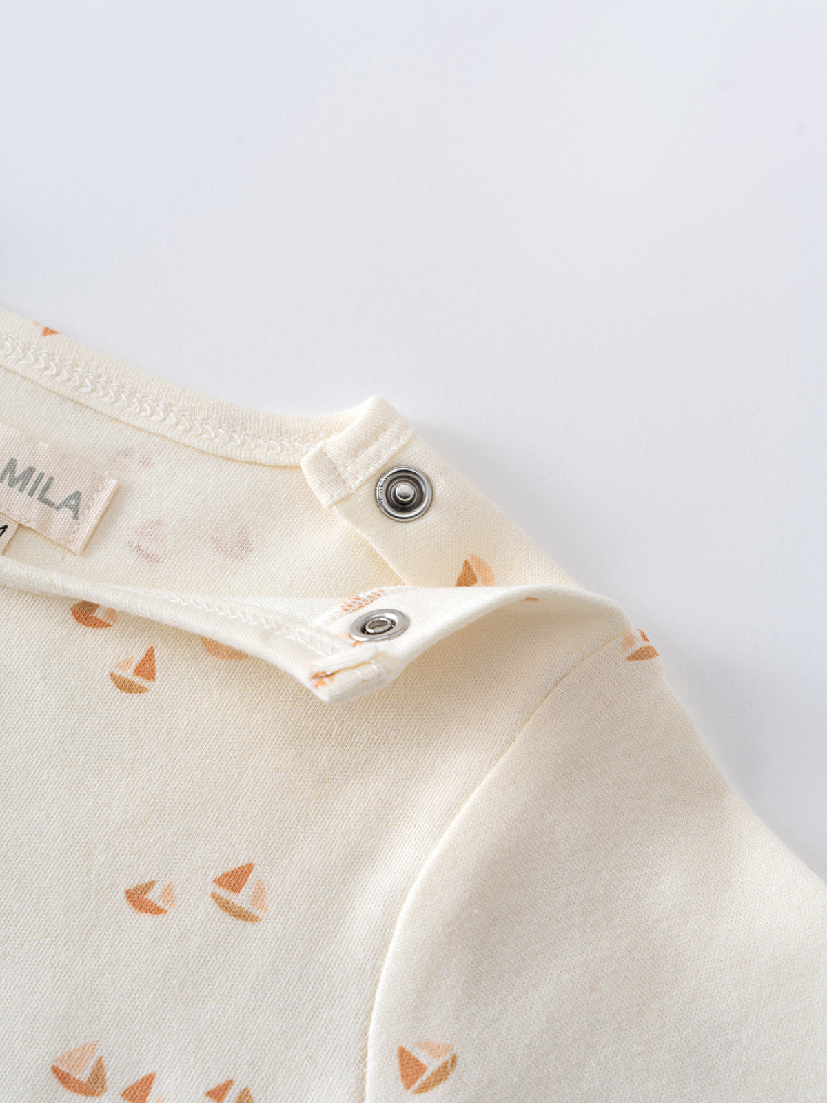 Close-up of cream bodysuit with orange print and snap buttons Matt Short Sleeve Bodysuit - Sailing Baby boy