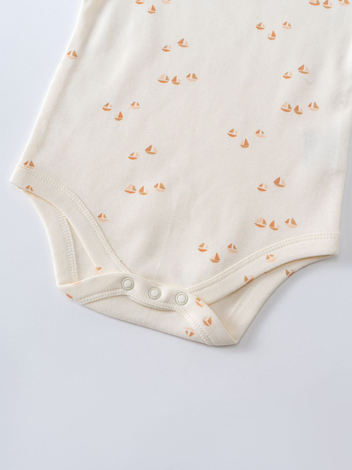 Close-up of cream baby bodysuit with small orange sailboat print and snap closure Matt Short Sleeve Bodysuit - Sailing Baby boy
