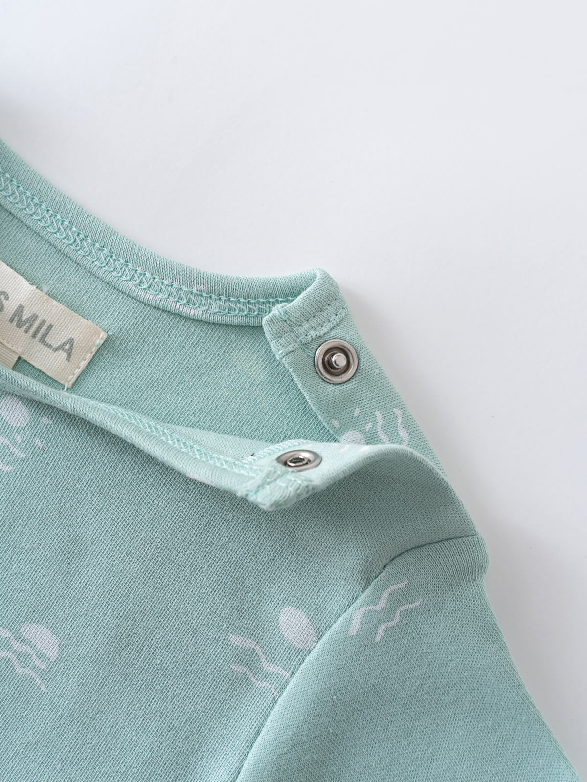 Close-up of a mint green baby bodysuit with snap buttons and label Matt Short Sleeve Bodysuit - Summer Time Baby boy
