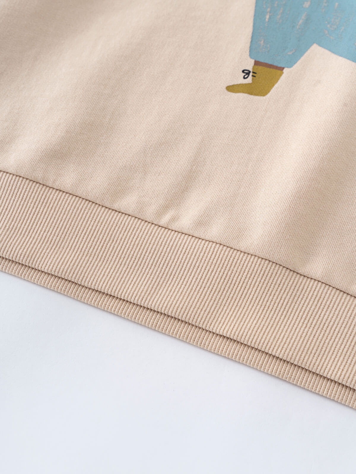 Close-up of beige sweatshirt hem with printed bear design wearing blue jacket Feature Print Sweatshirt - Hiking Bear Baby boy