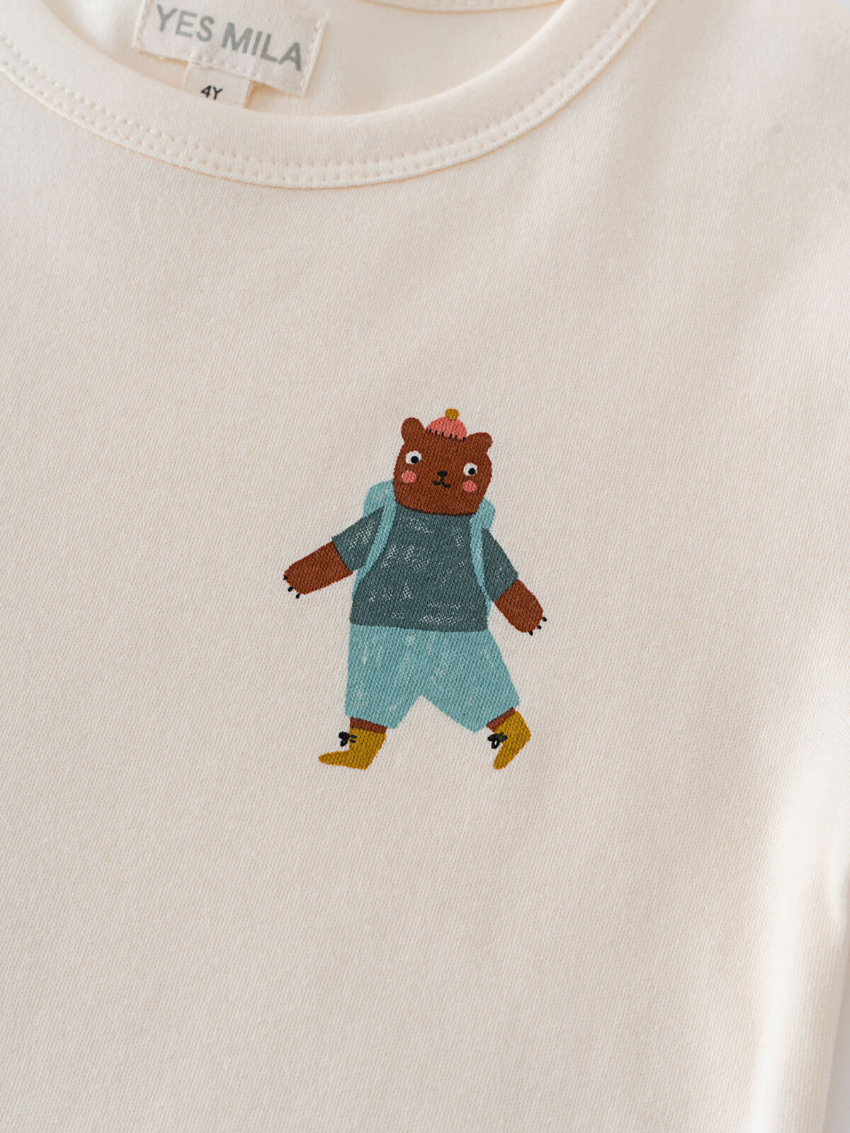 Cream colored shirt with embroidered brown bear wearing blue outfit and yellow boots Feature Print Short Sleeve Tee - Hiking Bear Boys