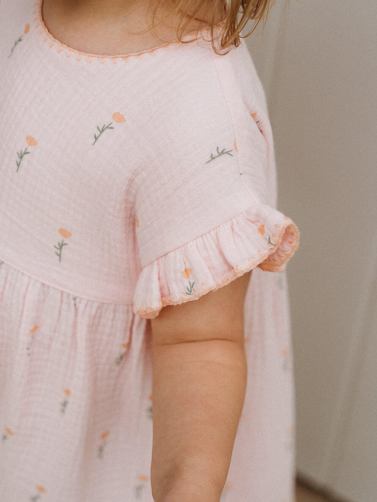 Child wearing a light pink dress with floral embroidery on a neutral background Muslin Dress - Poppy Field Girls