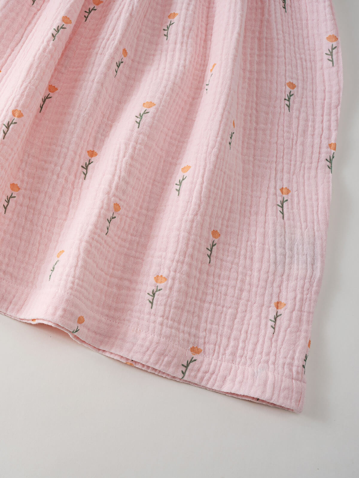 Pink textured fabric with floral patterns on a light gray background Muslin Dress - Poppy Field Girls