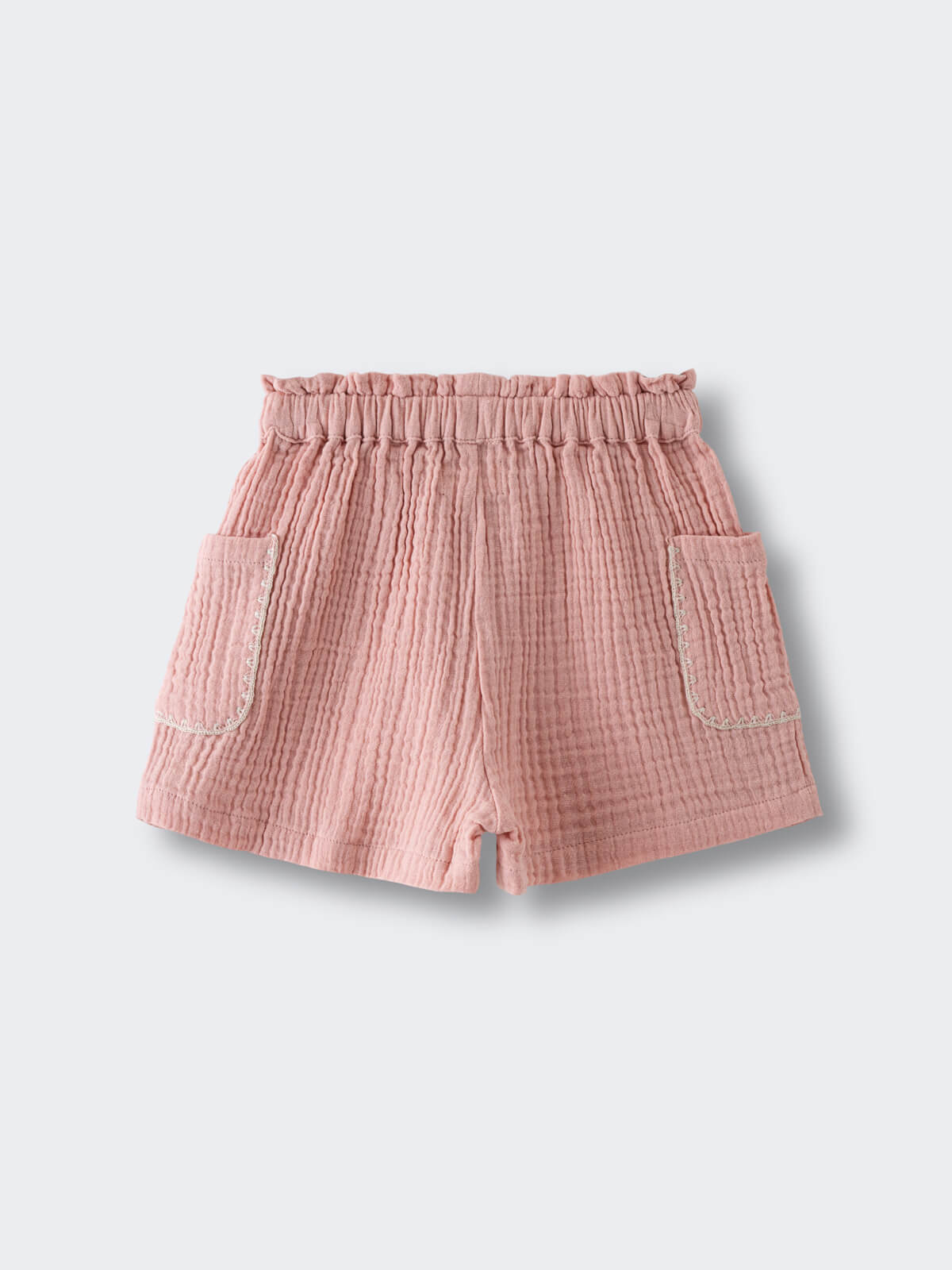Pink textured shorts with elastic waistband and front pockets on white background Muslin Shorts - Toasted Peach Girls
