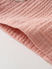 Close-up of pink textured fabric with ribbed pattern and hemmed edge Muslin Shorts - Toasted Peach Girls