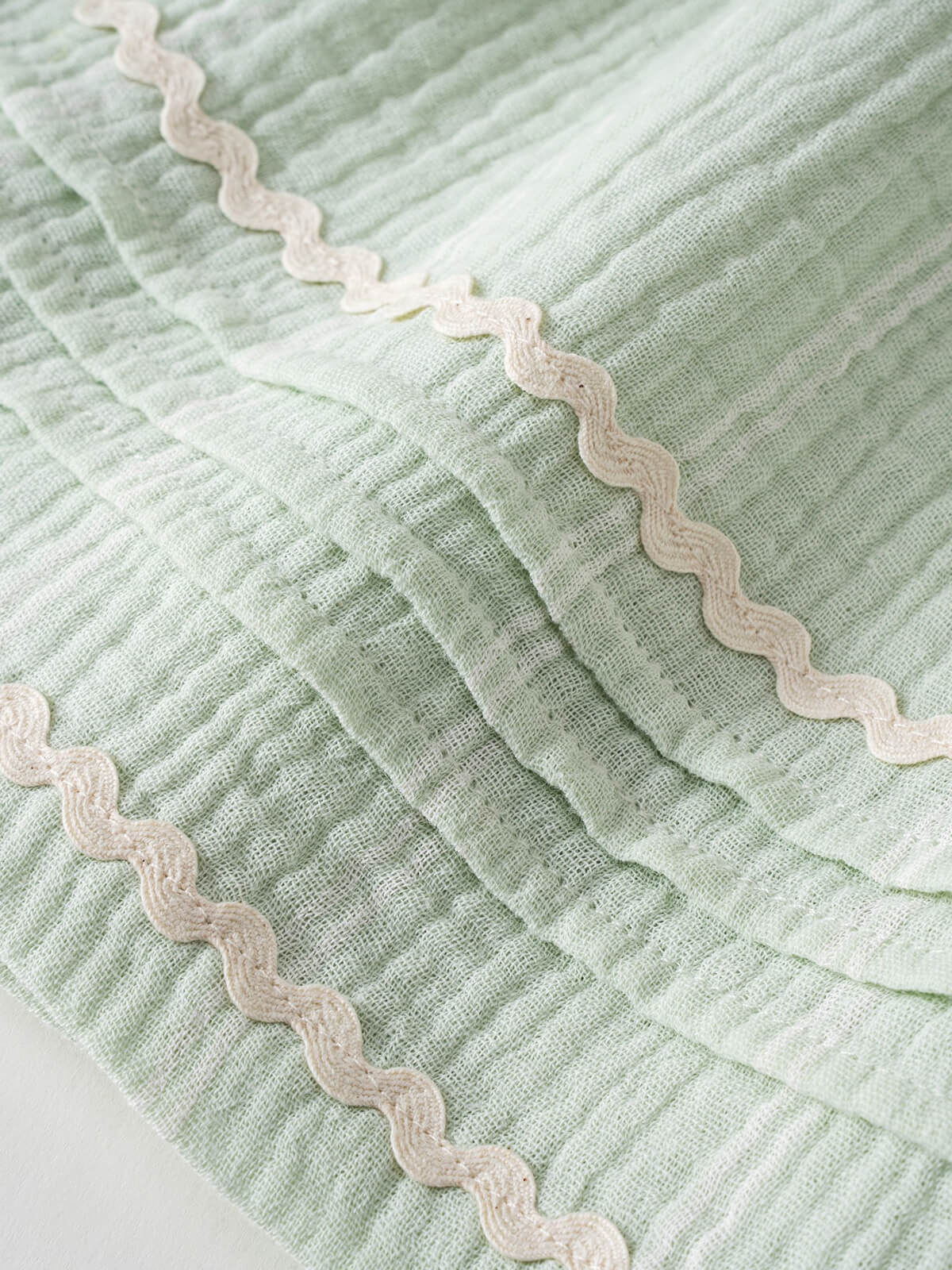 Close-up of light green striped fabric with wavy cream trim detail Muslin Skirt - Light Green Stripe Girls