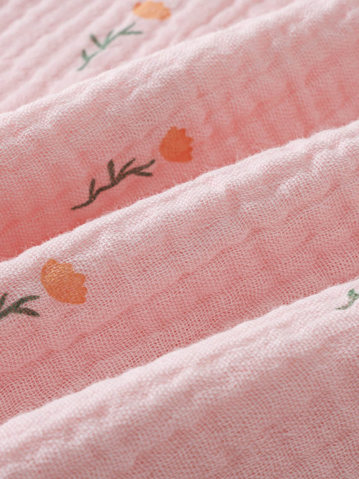 Close-up of pink fabric with small orange flowers and green leaf pattern Muslin Top - Poppy Field Girls