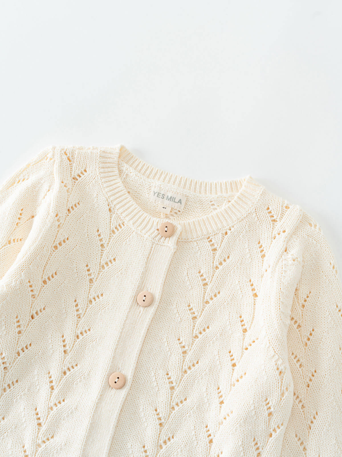Cream-colored cardigan with button details on a light gray background Pointelle Cardigan - Ecru Girls