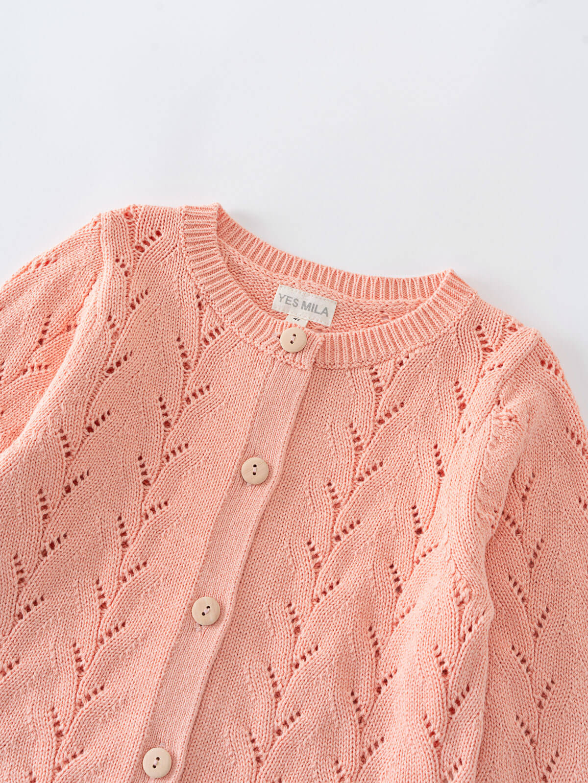 Pink cardigan with cable knit pattern with button details on a light gray background Pointelle Cardigan - Mallow Girls