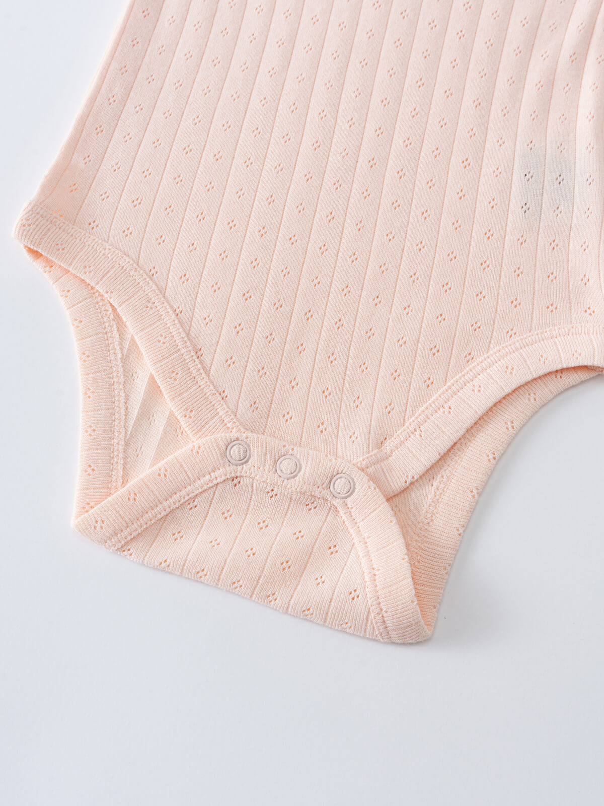 Close-up of ribbed baby bodysuit with snap buttons at crotch Pointelle Singlet Bodysuit - Shell Pink Baby girl