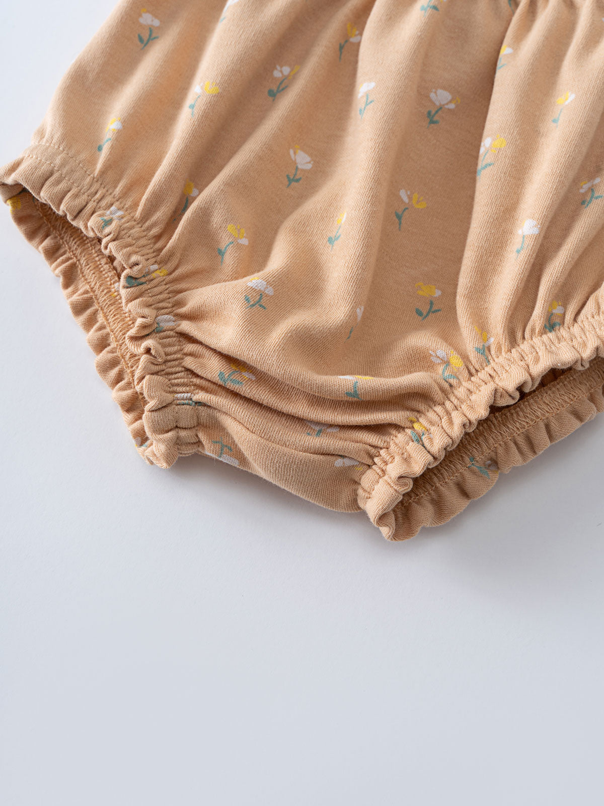 Close-up of beige fabric bloomers with small floral print and elastic gathering Printed Bloomers - Floral Bloom Baby girl