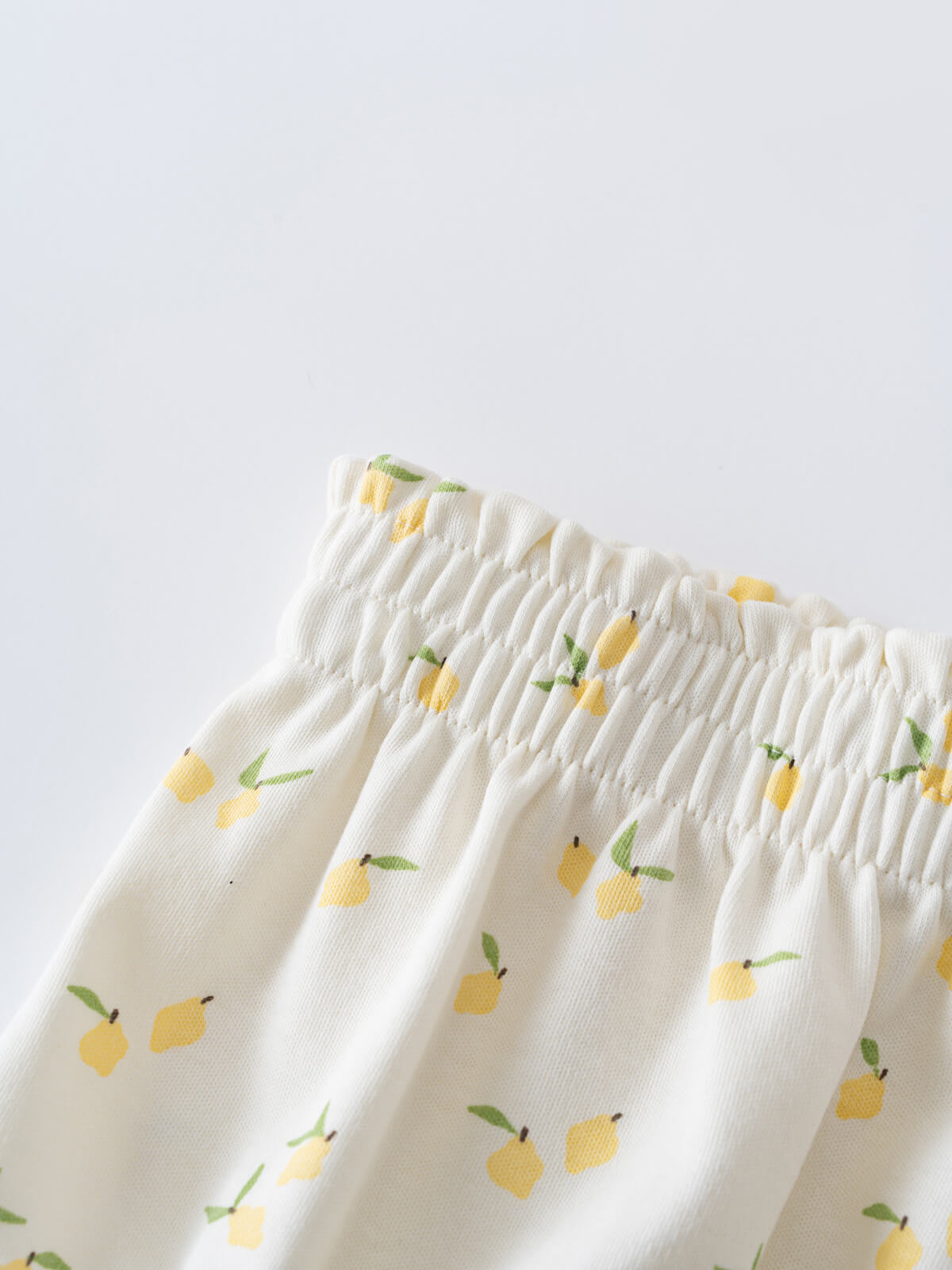 Close-up of white fabric waistband with yellow lemon and green leaf pattern Printed Bloomers - Lemons Baby girl
